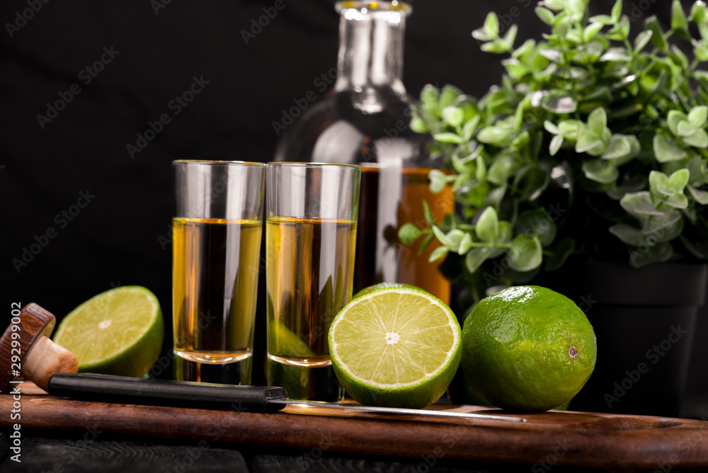Obraz premium Mexican Gold Tequila with lime and salt on black background with copyspace.