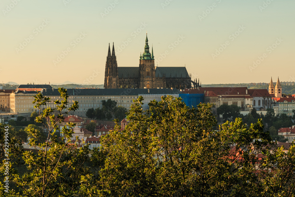 Panoramic view of Prague Castle with the St. Vitus Cathedral over the rooftops of the district Mala Strana from the viewpoint Petrin on sunny day with blue sky