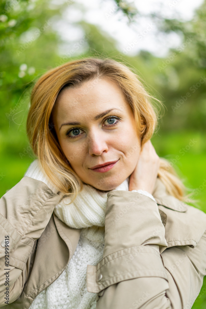 Beautiful blond woman posing outdoors at the blur spring park of violet and white lilac background Beautiful blond woman posing outdoors at the blur spring park of violet and white lilac background