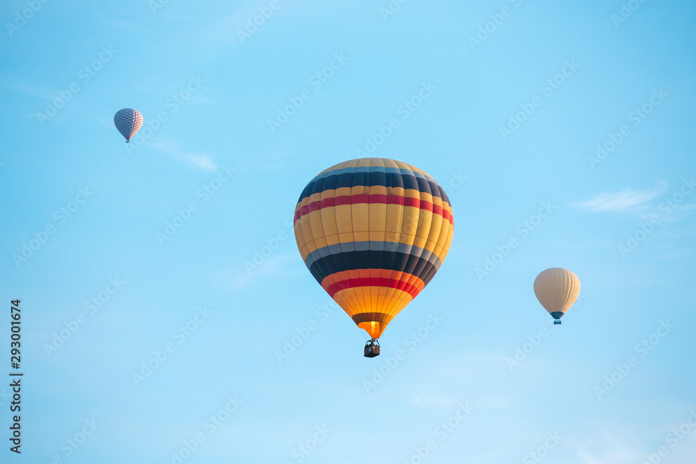 Fototapeta premium Many colorful hot air balloons flight above mountains - panorama of Cappadocia at sunrise. Wide landscape of Goreme valley in Cappadocia - billboard background for your travel concept in Turkey.