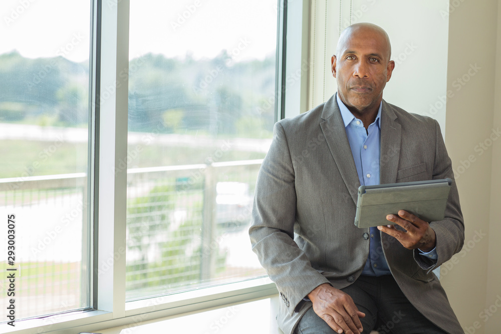 Mature African American man working on a tablet. Mature African American man working on a tablet.