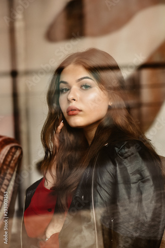 Portrait of beautiful woman, captured through the window glass © dmytro_khlystun
