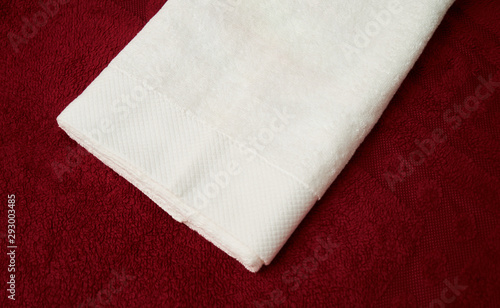 White and red towel fabric texture, close-up. Folded terry towel