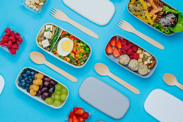 Pattern of lunch boxes filled with healthy food on blue background