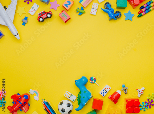 Frame of kids toys on yellow background with copyspace
