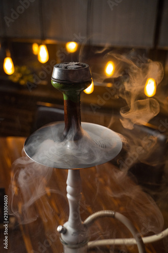 Hookah in a thick smoke with lights on background