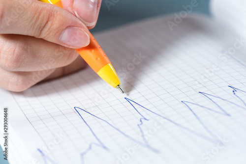 Stock trader draws a stock price chart close up background.