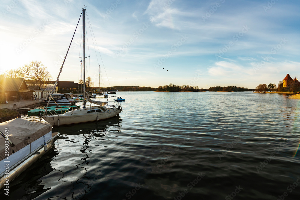 Fototapeta premium White yacht and Trakai castle in background in Trakai, Lithuania.