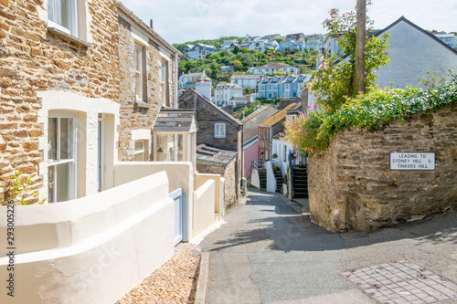 Old stone cottages on narrow street in beautiful Cornish harbour town Polruan, South Cornwall, UK