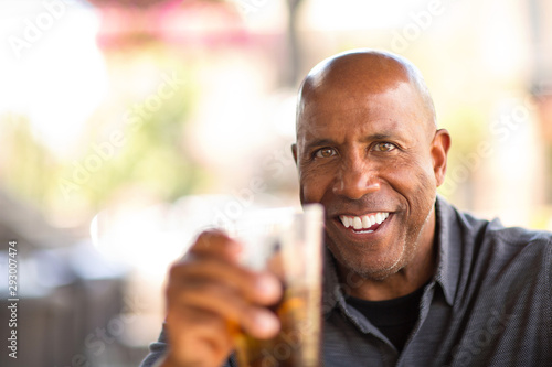Mature African American man drinking at a restaurant.
