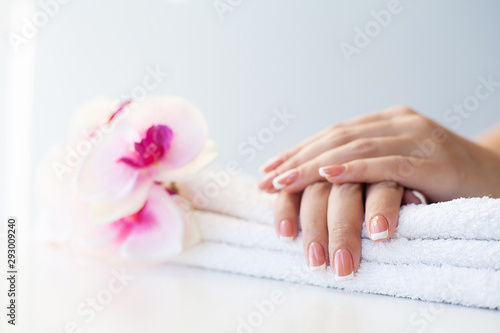 Beautiful woman s nails with french manicure  in beauty studio