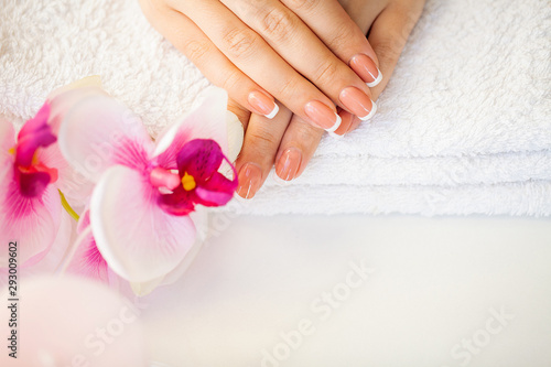 Beautiful woman's nails with french manicure, in beauty studio