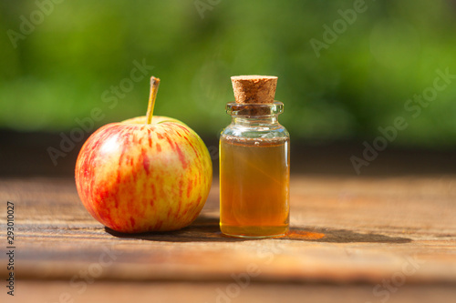 Apple essential oil in  beautiful bottle on table