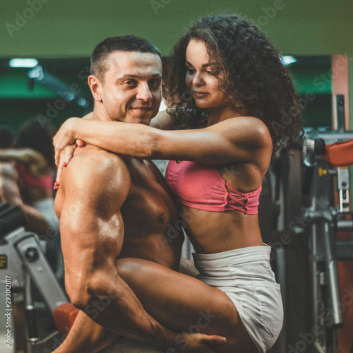  sportive couple in gym . muscular woman and man in gym.sportive life. fitness. gym. hot curly woman. handsome bodybuilder © Viktoria