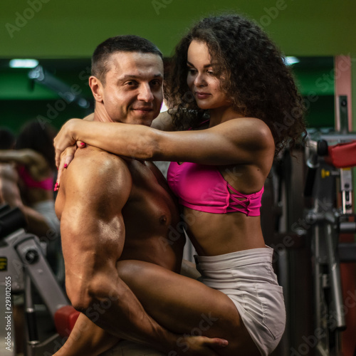  sportive couple in gym . muscular woman and man in gym.sportive life. fitness. gym. hot curly woman. handsome bodybuilder