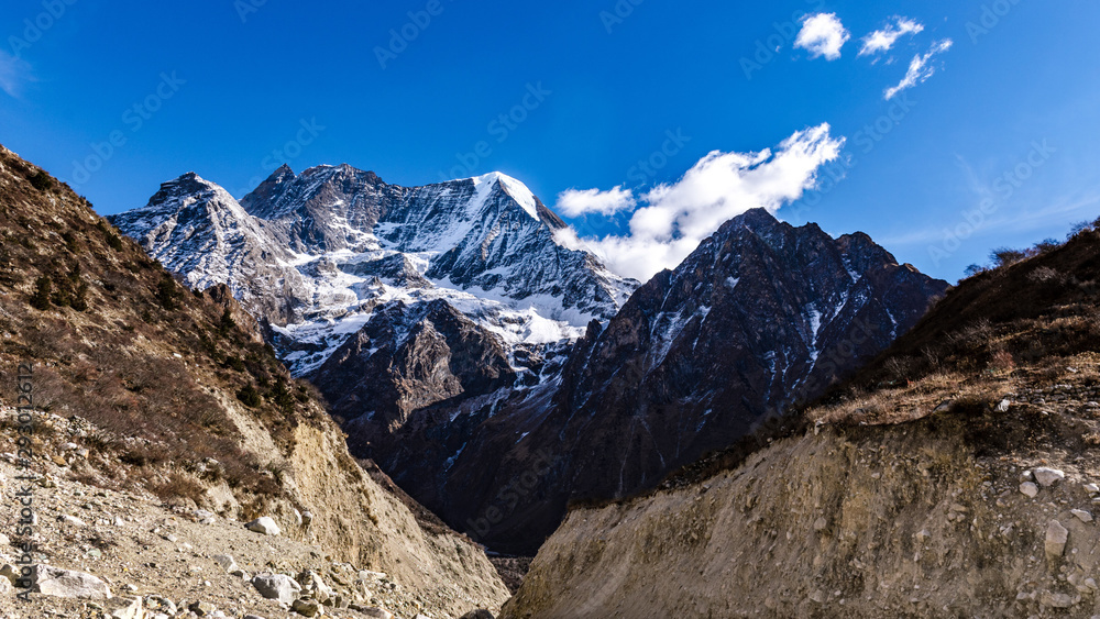Snow covered mountain peaks in Himalayas, Nepal during bright sunny day with blue sky.	