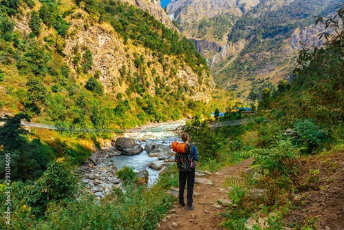 Male trekker from behind in rocky valley in Himalaya mountains in Nepal.