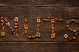 Nuts symbol as letters made with a mixed assortment of raw seeds of different nuts