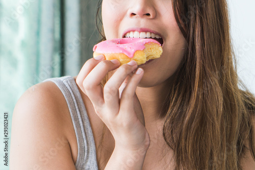 Woman cheating during diet and eating doughnut. selective focus on mouth.