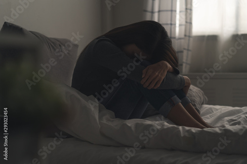 Suffer from depression , mental health problem. asian young woman sitting on the bed feeling depressed. © Pormezz
