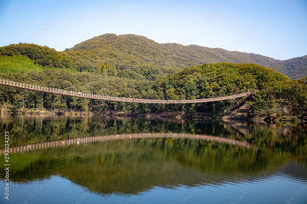 Suspension bridge connected to the mountain across the lake Suspension bridge connected to the mountain across the lake