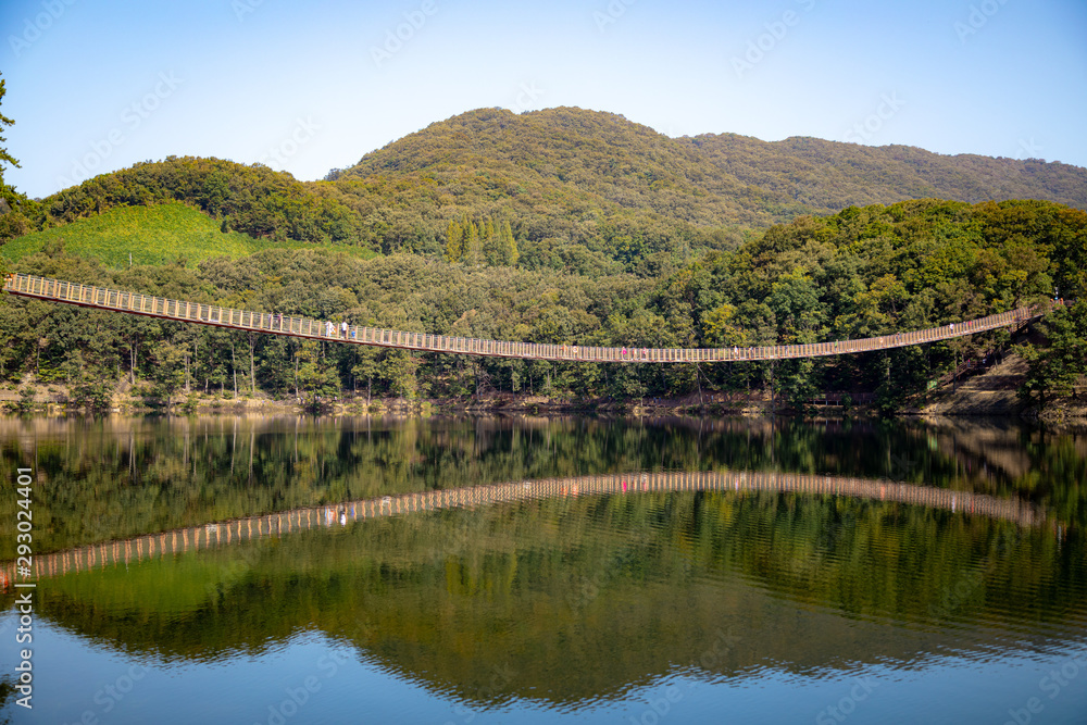 Suspension bridge connected to the mountain across the lake