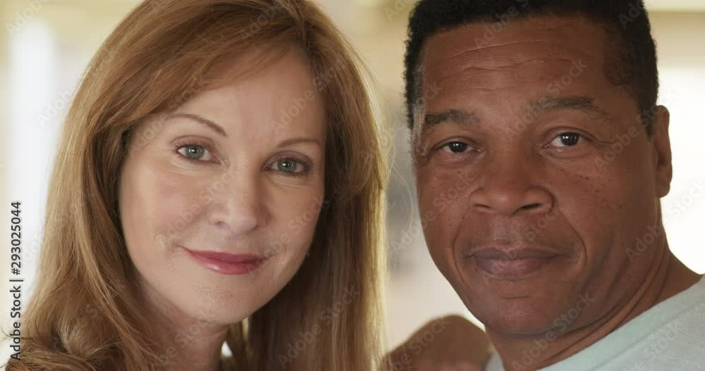 Close up portrait of happy older African American Husband and Caucasian wife at home. Married couple smiling at home and looking at camera. Slow Motion 4k Handheld Close up portrait of happy older African American Husband and Caucasian wife at home. Married couple smiling at home and looking at camera. Slow Motion 4k Handheld