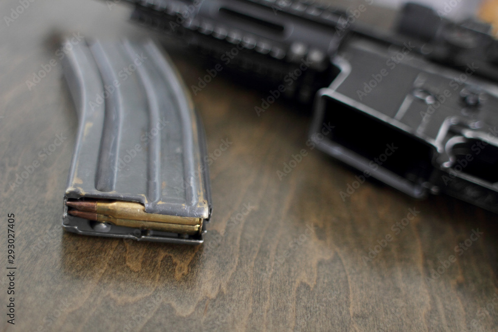 High capacity magazine with bullets next to an AR15 on a table in a ...