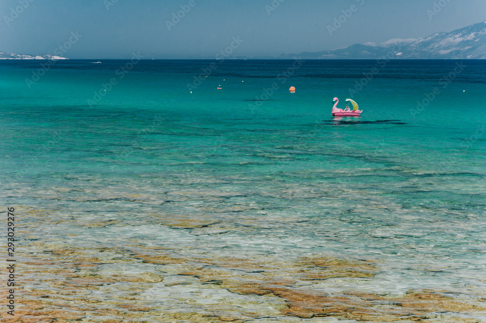 Aerial shot of beautiful blue lagoon at hot summer day with sailing boat. Top view of people are swimming around the boat. Aerial shot of beautiful blue lagoon at hot summer day with sailing boat. Top view of people are swimming around the boat.