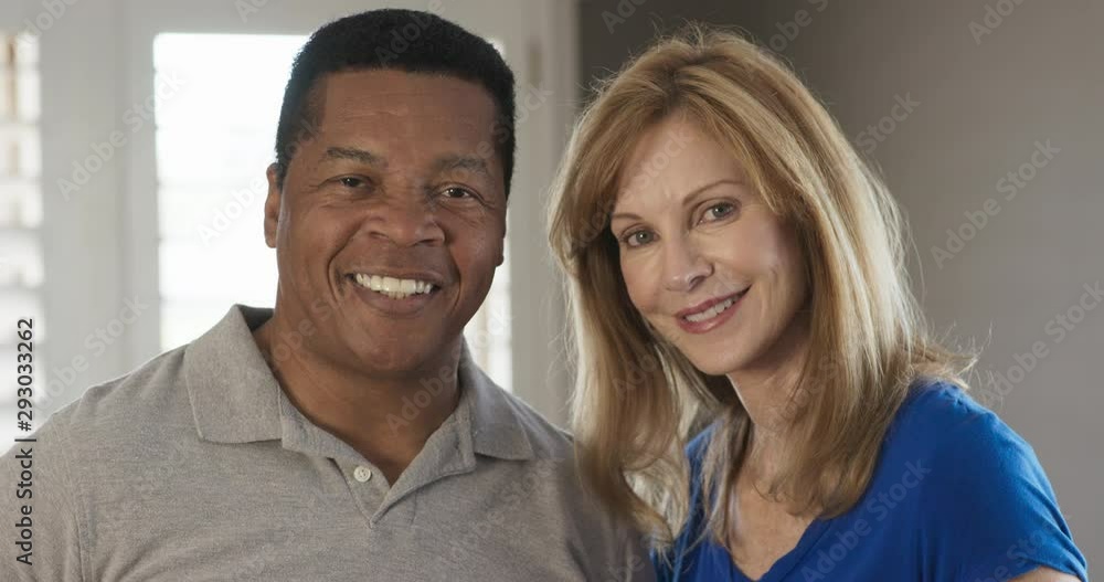 Close up portrait of smiling older African American Husband and Caucasian wife at home. Married couple happy at home and looking at camera. Slow Motion 4k Handheld Close up portrait of smiling older African American Husband and Caucasian wife at home. Married couple happy at home and looking at camera. Slow Motion 4k Handheld