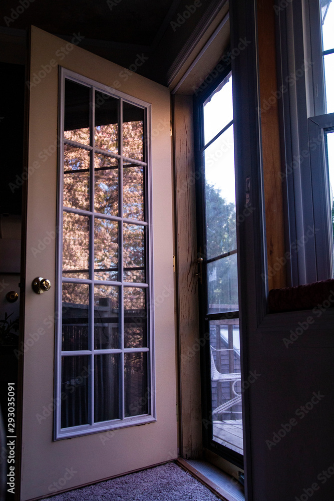 Fototapeta premium Crabapple Blossoms Are Reflected in the Panes of an Open Door