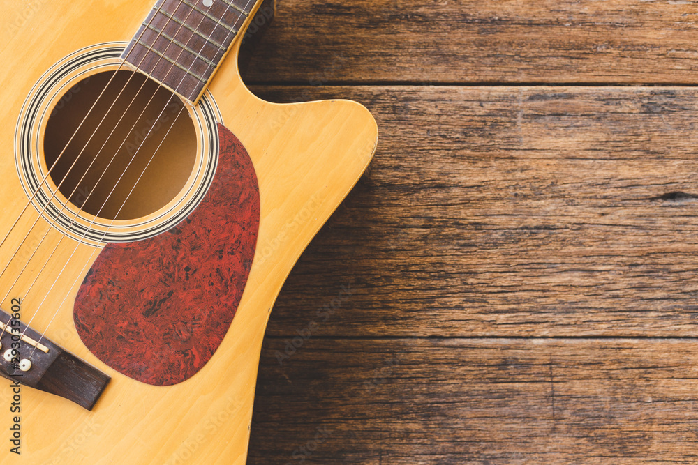 Fototapeta premium Top view of Acoustic guitar on wood background and copy space