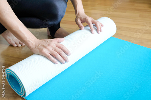 Women are yoga mat  blue rolls. Fitness room