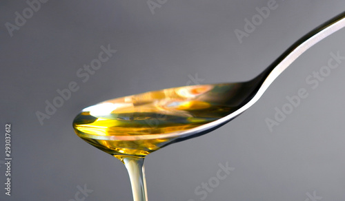 Pouring olive oil in the a spoon at kitchen. Prepare for cooking concept. Healthcare and Beauty Concept.