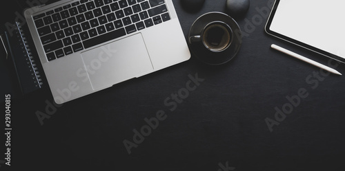 Dark luxury workplace with copy space laptop computer and office supplies on black leather
