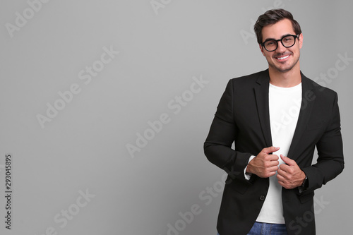 Handsome young man in casual clothes on grey background. Space for text