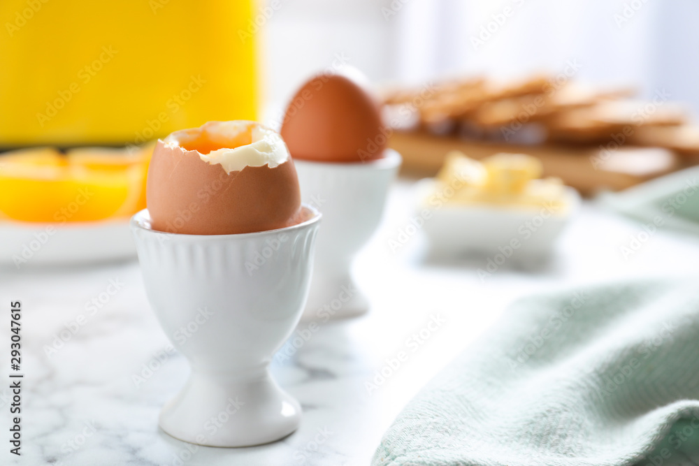 Cups with soft boiled eggs on marble table, space for text. Healthy breakfast Cups with soft boiled eggs on marble table, space for text. Healthy breakfast
