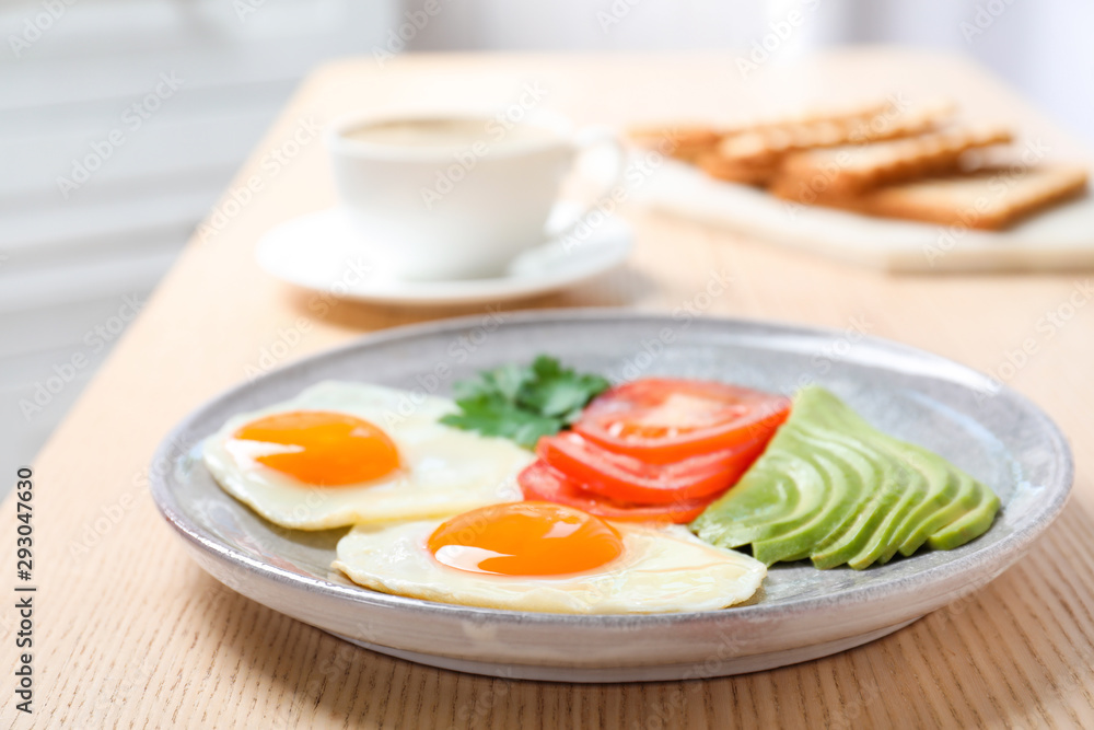 Plate with fried eggs and vegetables on wooden table. Healthy breakfast Plate with fried eggs and vegetables on wooden table. Healthy breakfast