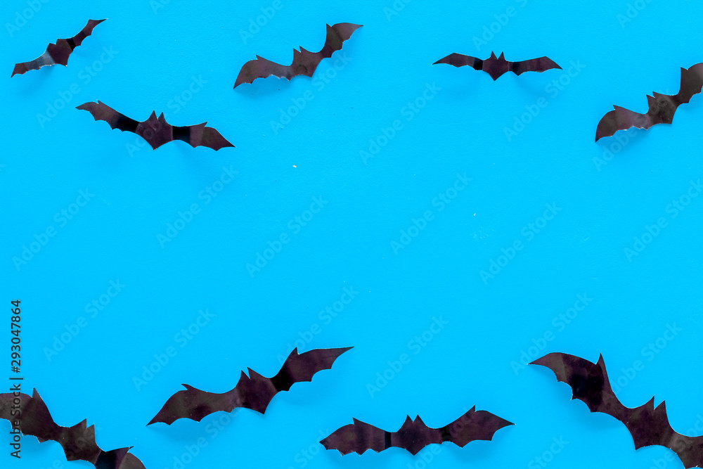 Obraz premium Bats cutout on Halloween frame on blue table top view copy space