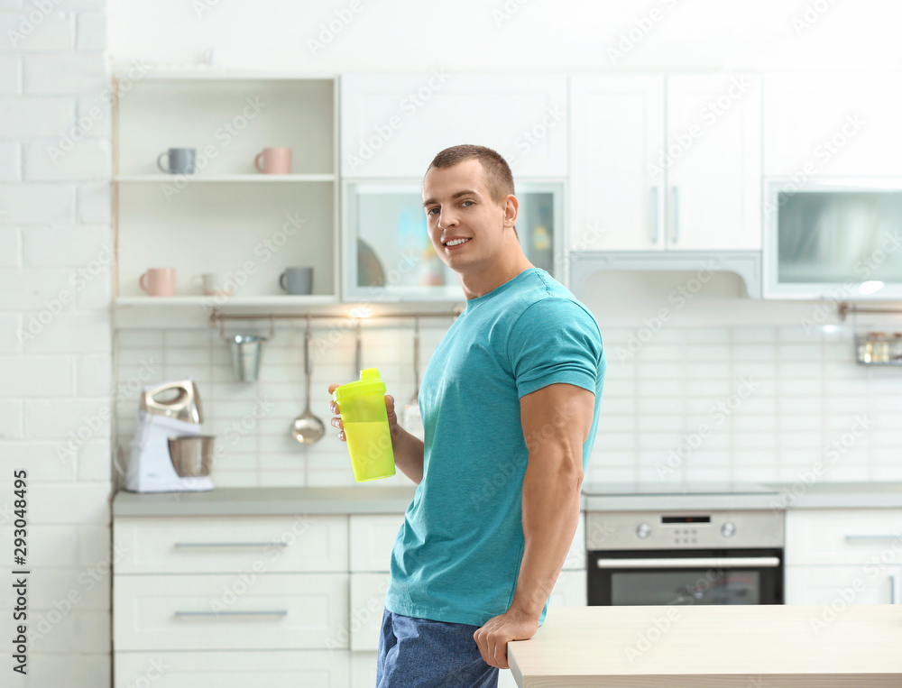 Athletic young man with protein shake in kitchen Athletic young man with protein shake in kitchen