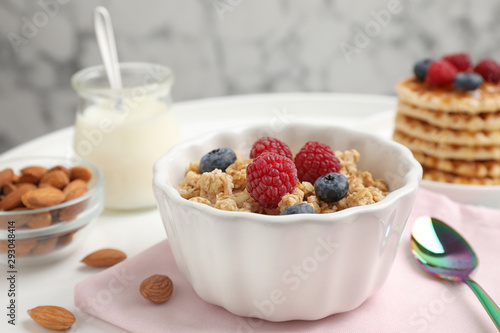 Healthy breakfast with granola and berries served on white table