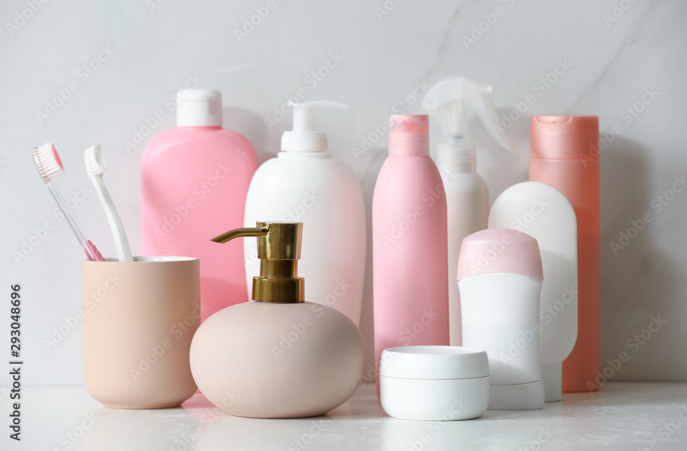 Stick deodorant and different toiletry on marble table near light wall Stick deodorant and different toiletry on marble table near light wall
