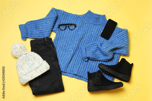 Flat lay composition with winter clothes and boots on yellow background