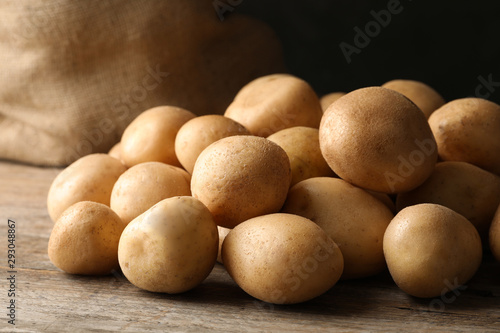 Raw fresh organic potatoes on wooden table