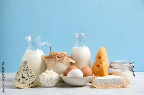 Tableau sur toile Different dairy products on white table against blue background