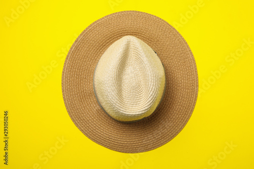 Stylish hat on yellow background, top view