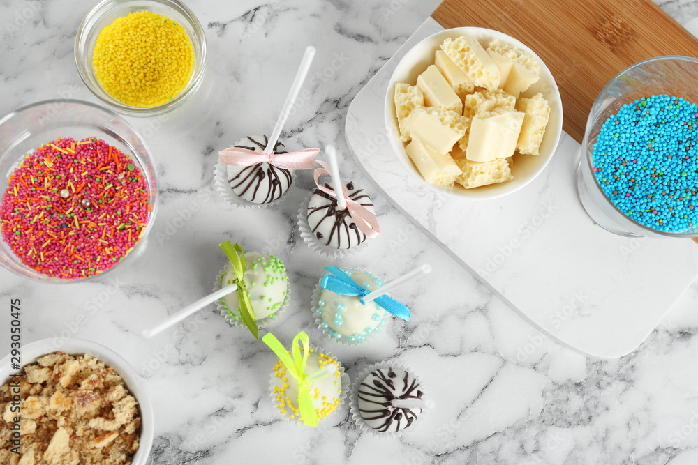 Flat lay composition with tasty cake pops on white marble table Flat lay composition with tasty cake pops on white marble table