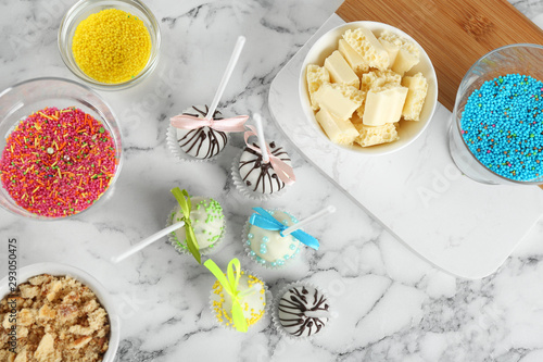 Flat lay composition with tasty cake pops on white marble table