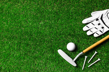 Flat lay composition with golf equipment on green course. Space for text