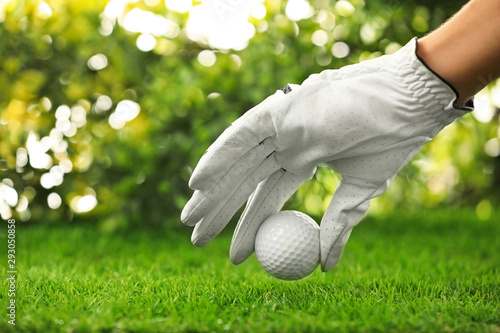 Player putting golf ball on green course, closeup